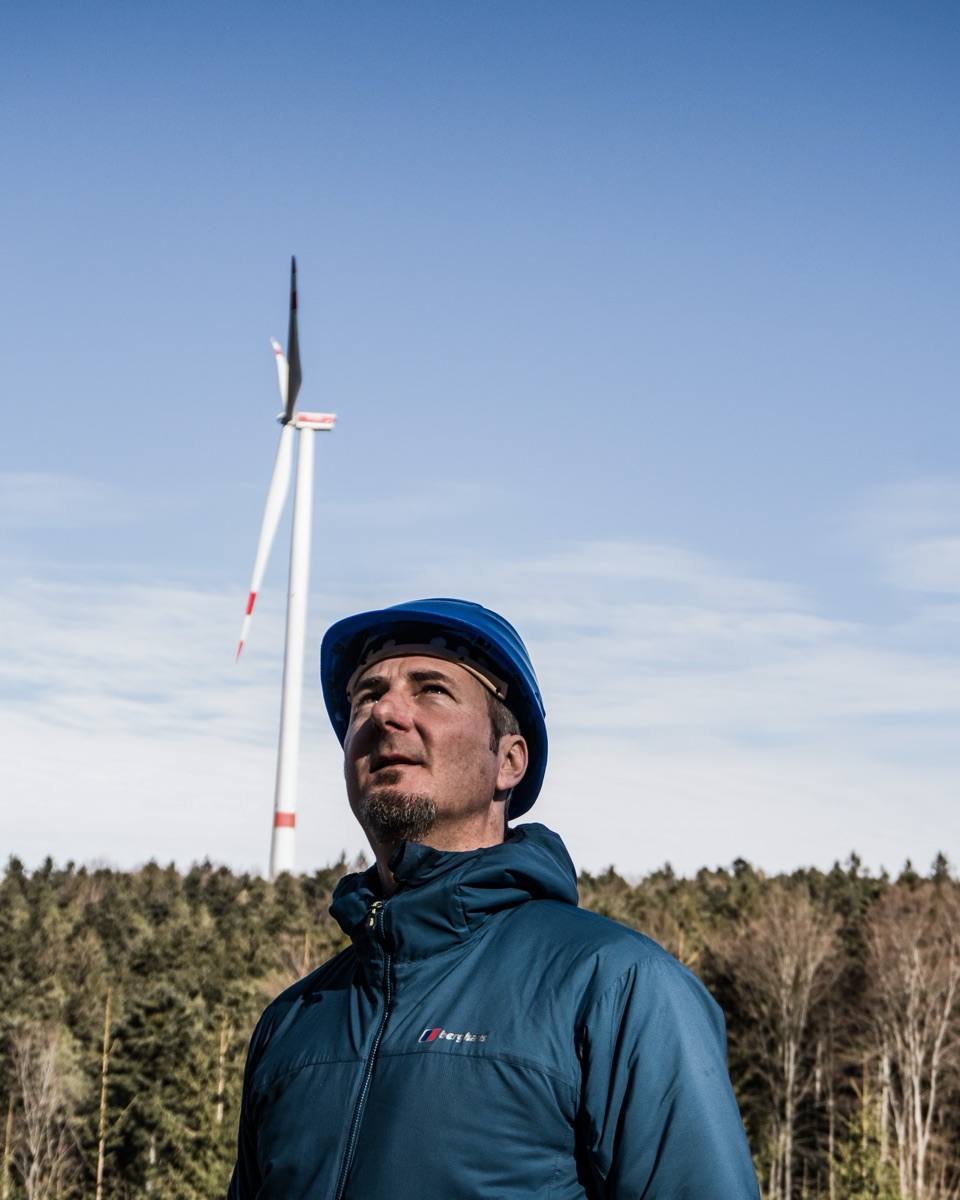 Geschäftsführer von E3 Energie vor einer Windenergieanlage im Schwarzwald